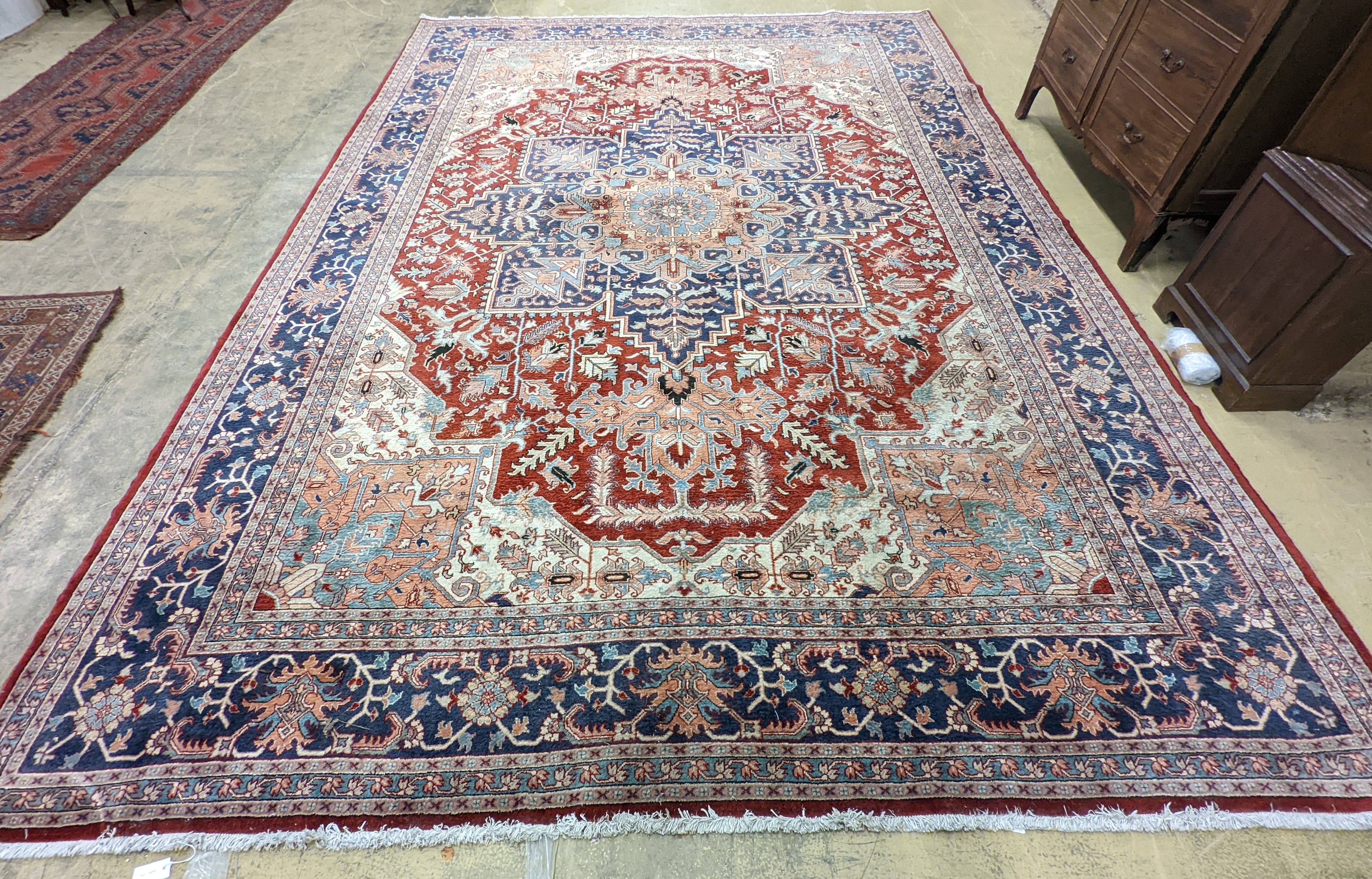 A large Caucasian style red ground carpet, 460 x 330cm